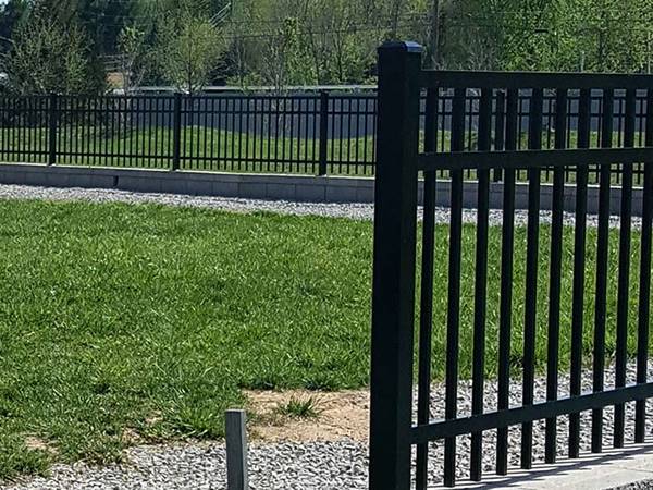 The black steel fence is installed beside the lawn.